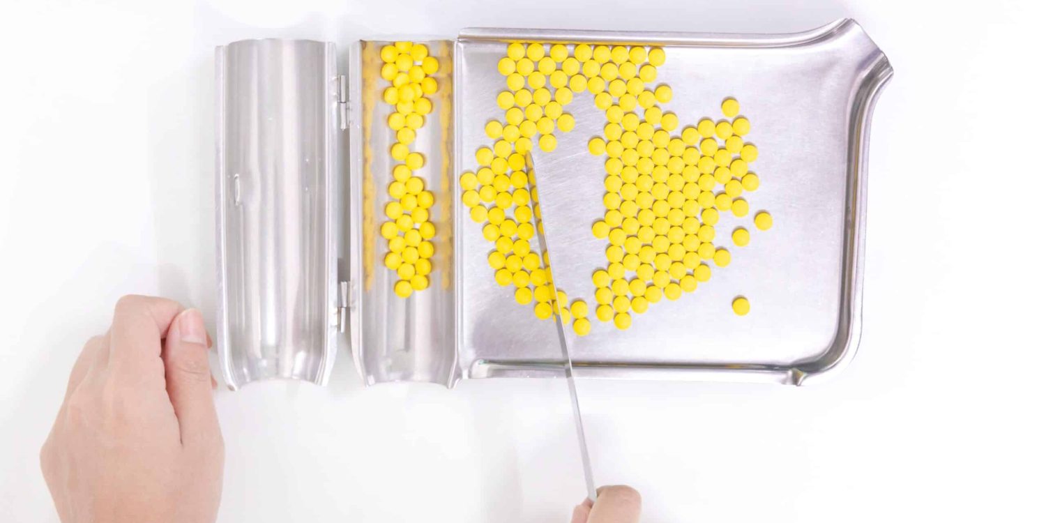a-person-separating-yellow-pills