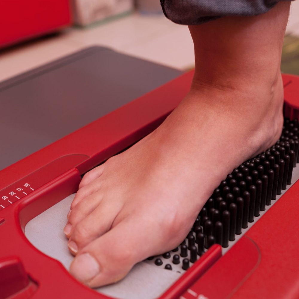 Close-up shot of foot being scanned on orthopedic device which creating a digital footstep model, helping to make perfect-fitting footwear